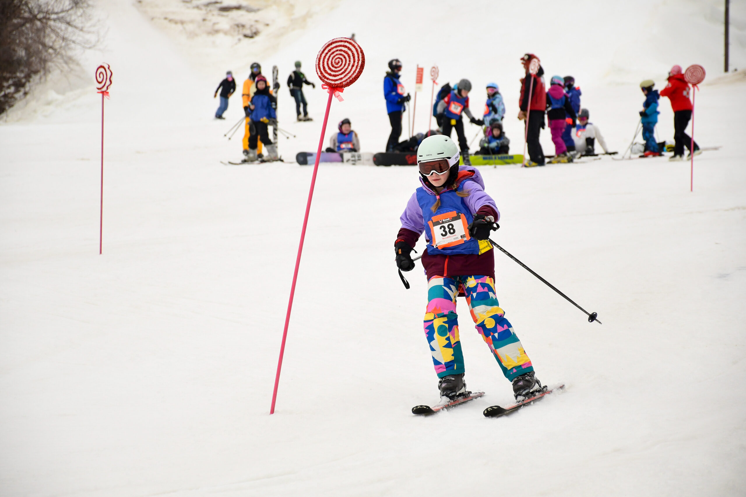 Child skiing between poles.